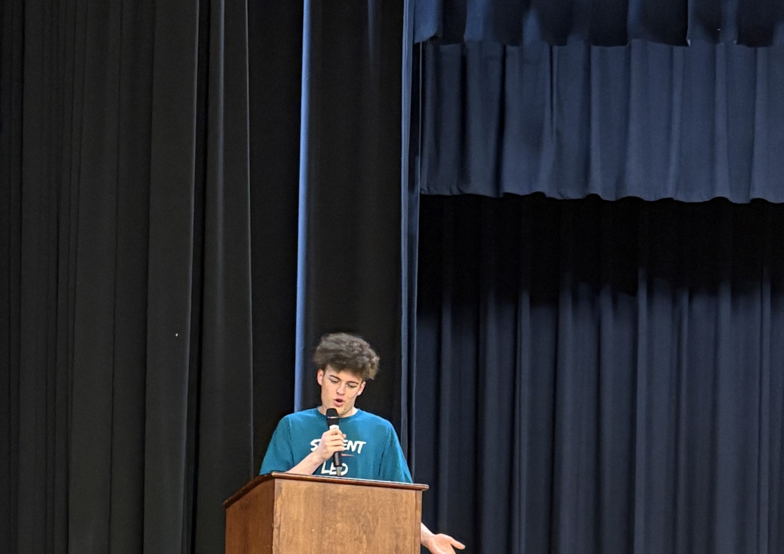 Grayton Faust speaking at the podium during the Student-Led Prayer Community Revival