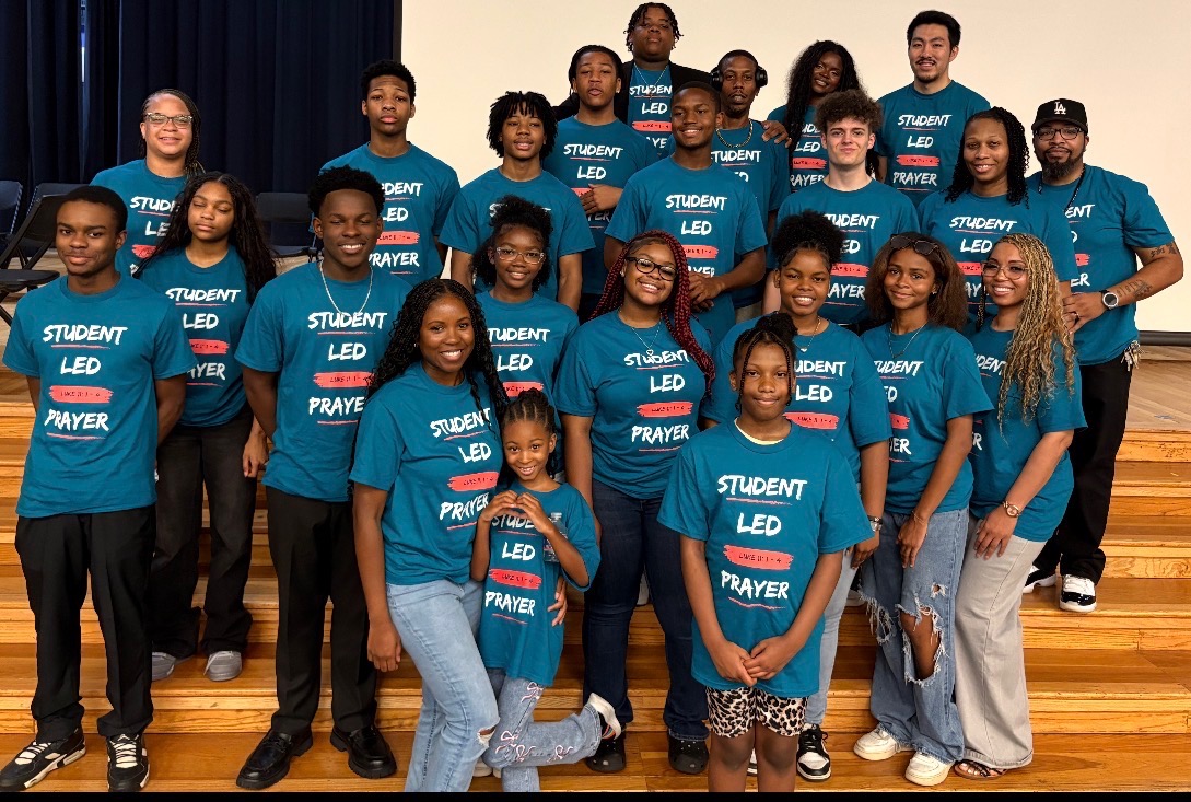 Students and adult volunteers wearing Student-Led Prayer T-shirts at a school event
